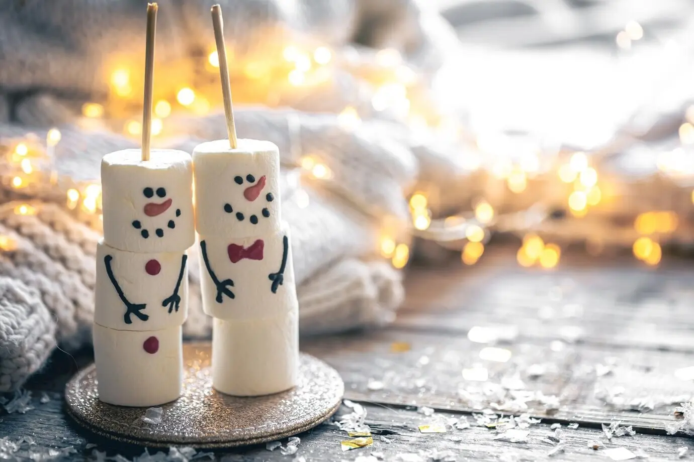 Gemütlicher weihnachtlicher Hintergrund mit Marshmallow-Schneemännern und festlicher Dekoration